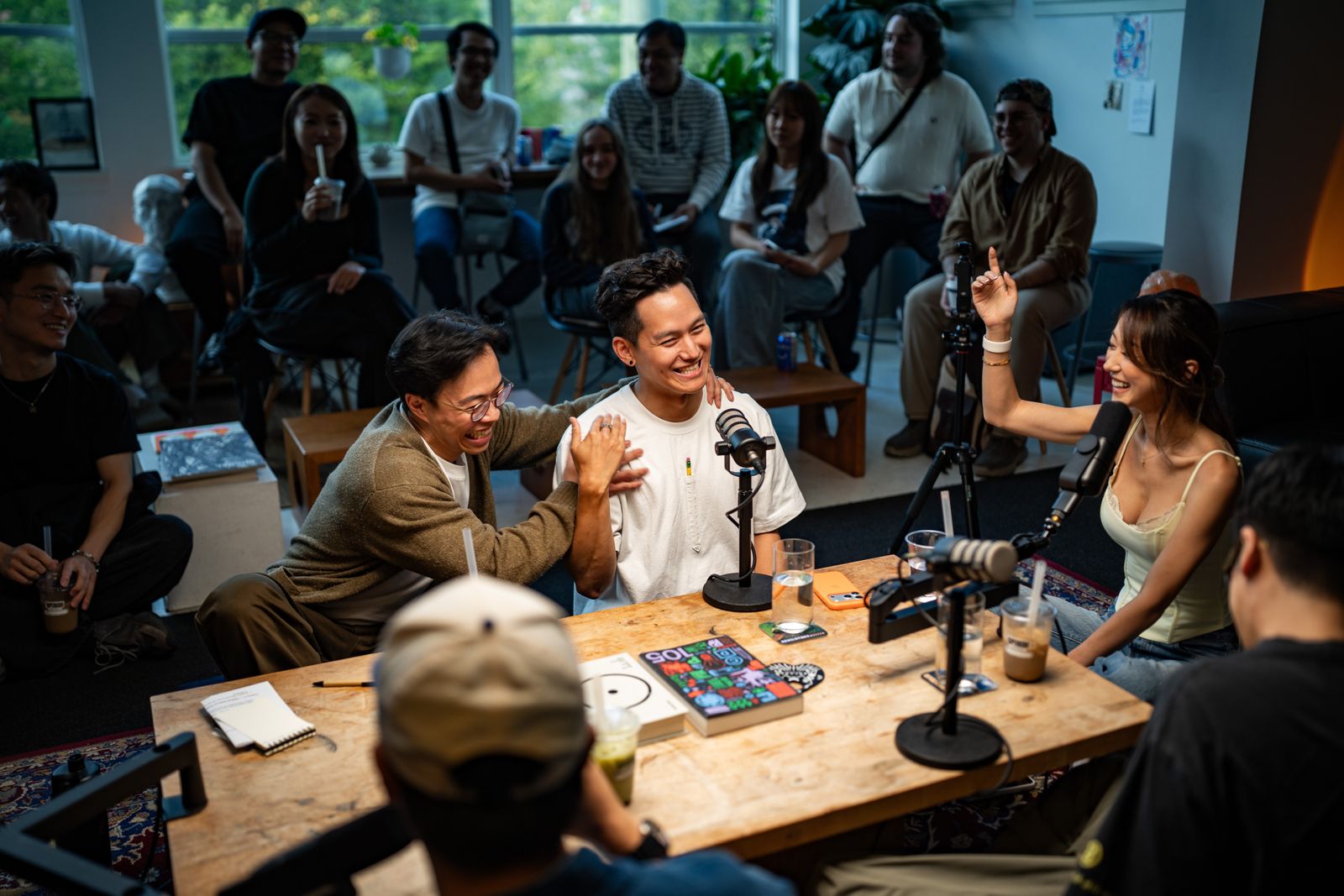Panelists laughing together at the table with the crowd behind